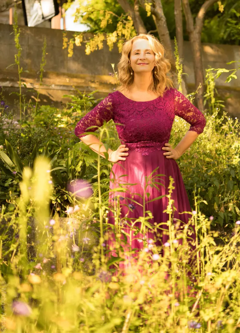 Im bordeauxroten Kleid im sonnigen Garten