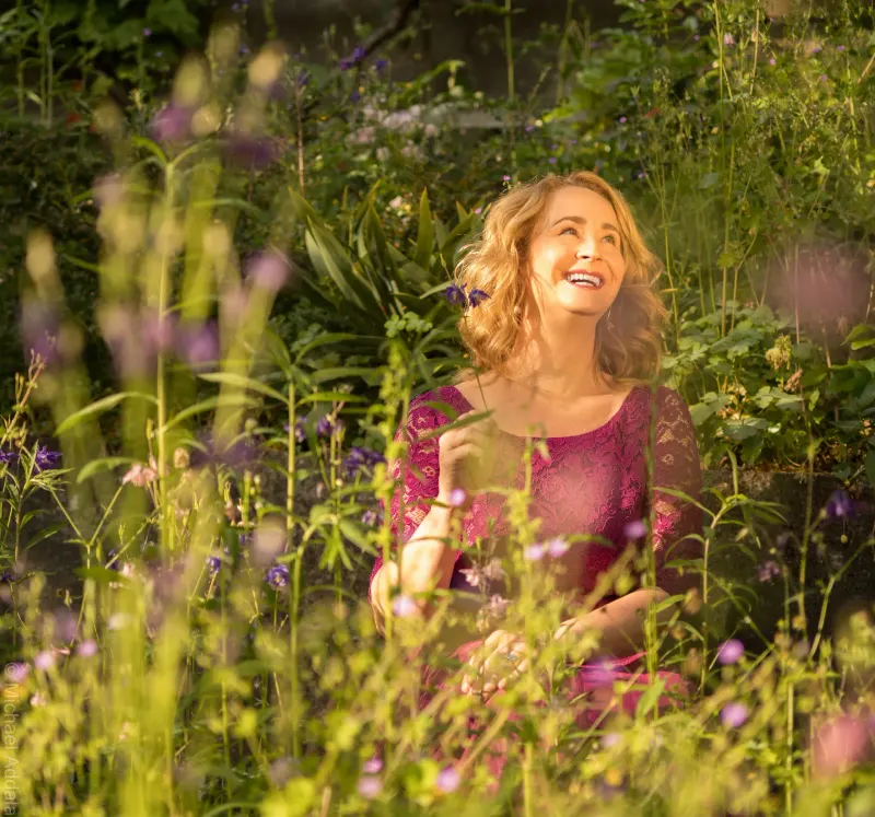 Christina Röckelein lachend in einer Blumenwiese